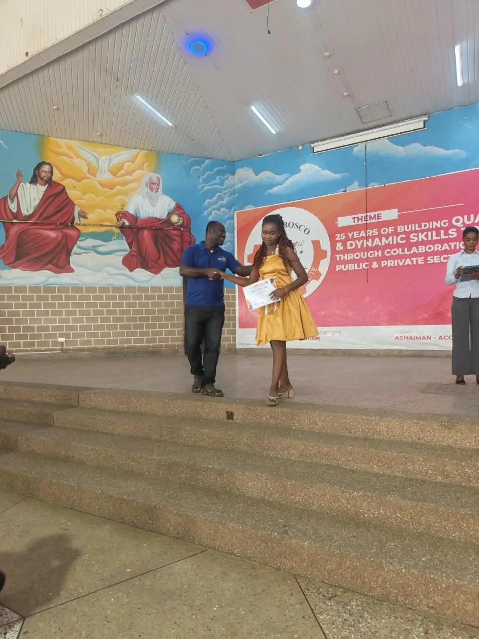 A trainee receiving her certificate on stage at DBTI