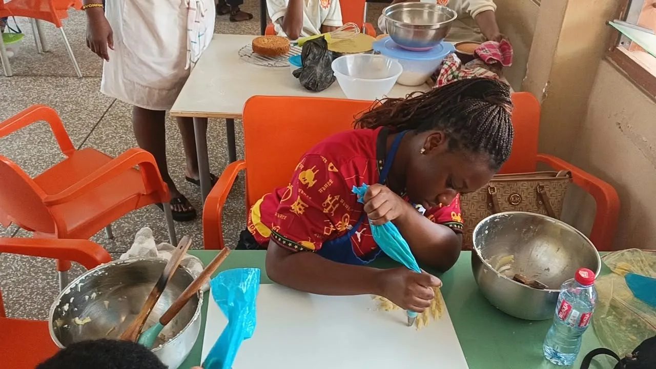 A trainee piping icing onto pastries